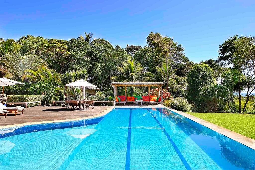 Piscina rasa e funda com vista para o mar.