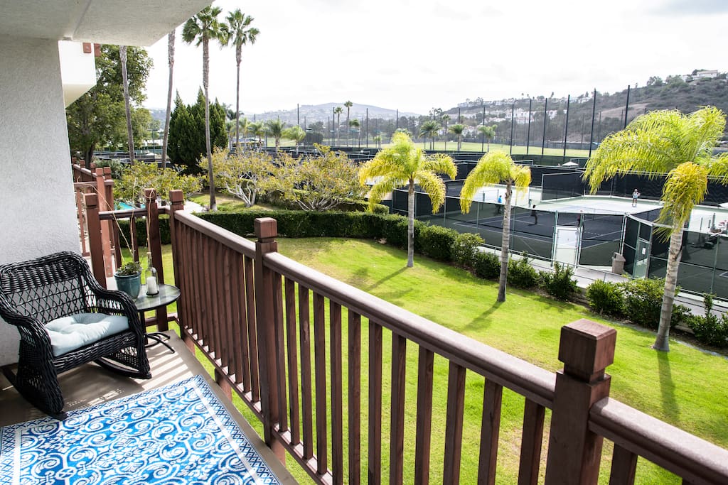 Balcony runs the length of condo with views of a resort's tennis courts