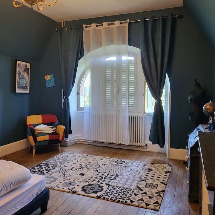 غرفة زرقاء بها حمام (حوض استحمام).
سرير مزدوج.
إطلالة على الجبال