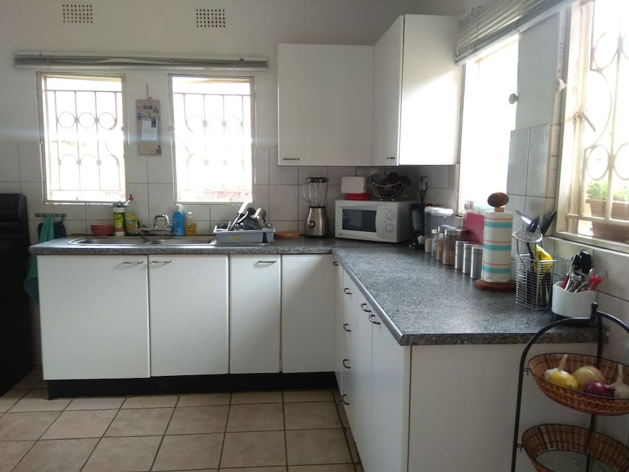Kitchen includes electric stove (with oven), fridge, microwave and coffee machine.