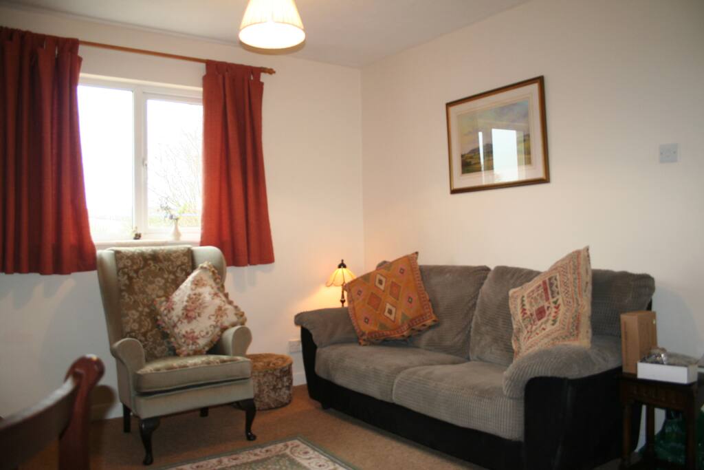 The cosy lounge with views over the garden and Devon countryside