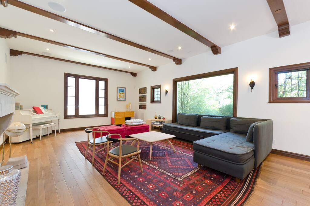 very large living room with a piano and a fireplace