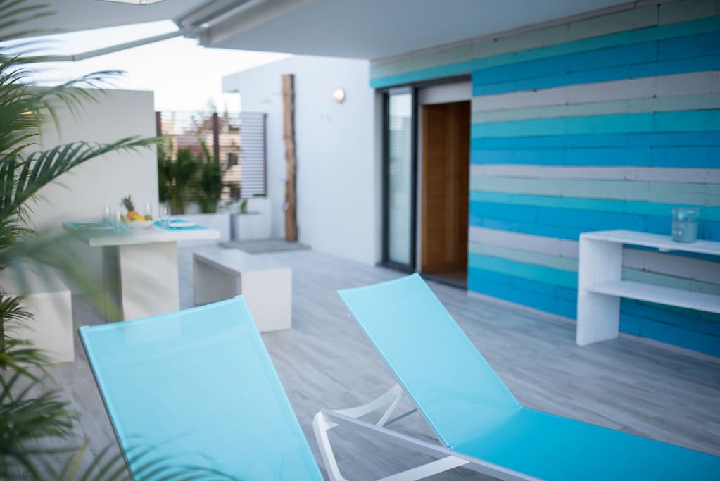 60m² Terrace with outdoor shower, table and sunbeds.