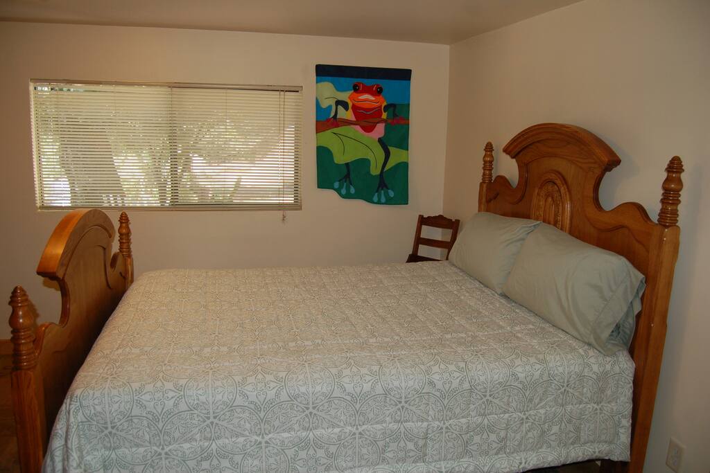 Master bedroom's queen oak bed. Private view is of trees and the garden