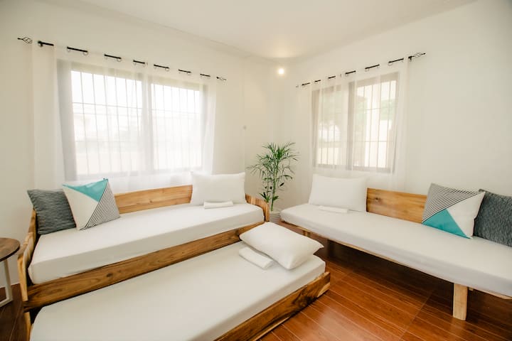 Non-airconditioned but well-ventilated and spacious LIVING AREA is on the 1st floor used as extra bedroom for 3 guests—8th to 10th guests will occupy the sofa beds and may enjoy lounging while watching Netflix. Fan is provided. 