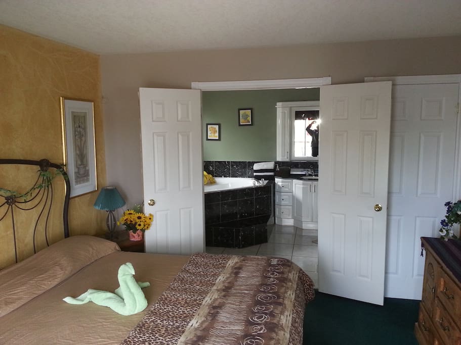 king suites ensuite to large bathroom with huge Jacuzzi hot tub spa and shower enclosure.