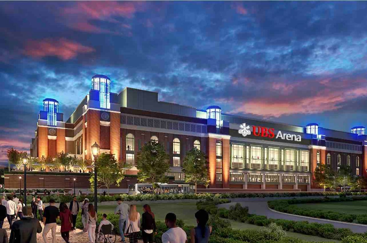 UBS Arena is depicted with its striking architecture, illuminated against a vibrant evening sky. The building is highlighted by tall towers and bright signage. Various people are seen in front of the arena, which is surrounded by green landscaping and pathways.