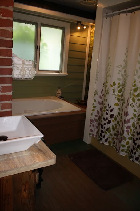 The private bathroom brings the outdoors inside with a woodland themed air-jet bath and whimsical, outdoor themed decor.