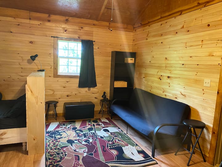 Cama futón con sistemas de estanterías. Ropa de cama en caja otomana.