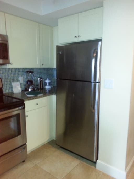 Kitchen has full size appliances including a range , microwave, cooktop, and microwave