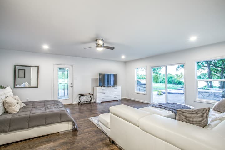 Dormitorio principal del piso principal:  el principal en el piso principal es una habitación muy grande con puertas corredizas que se abren al área de la terraza.  Preciosas vistas y una sensación muy pacífica.  El sofá y el salón extragrandes lo convierten en un lugar perfecto para sentarse a leer, trabajar o simplemente ver la televisión. ¡Desde la cama tamaño king puedes disfrutar de la vista del patio trasero hasta el lago!   