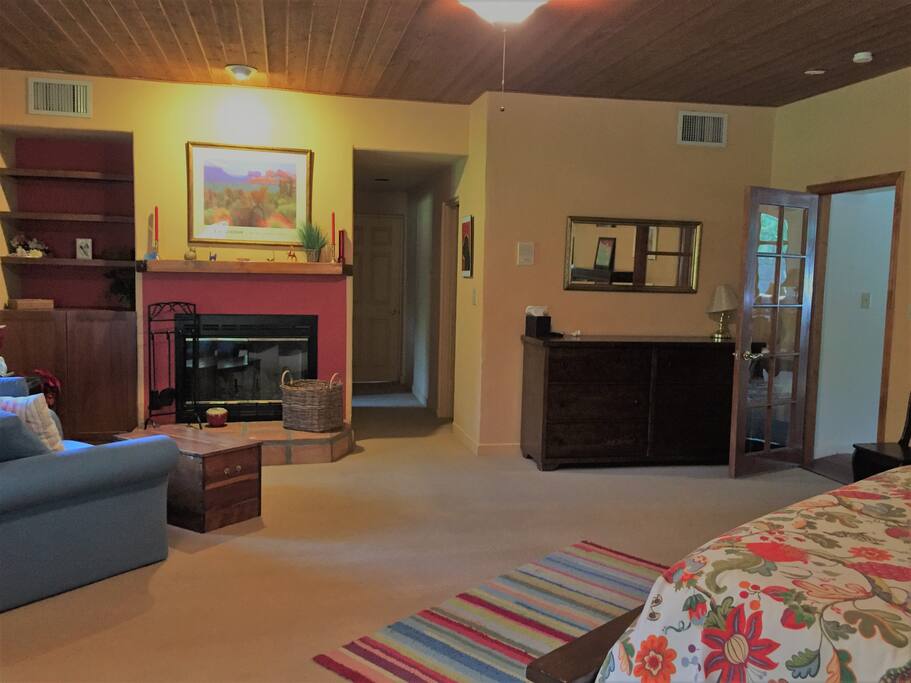 Mourning Dove Suite including fireplace and hall to en suite bathroom and walk-in closet. Door to right goes to Guest Common Space and Jacuzzi.