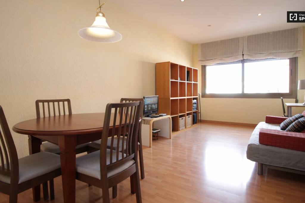 Salon con sofa, mesa de trabajo, TV, mesa y sillas