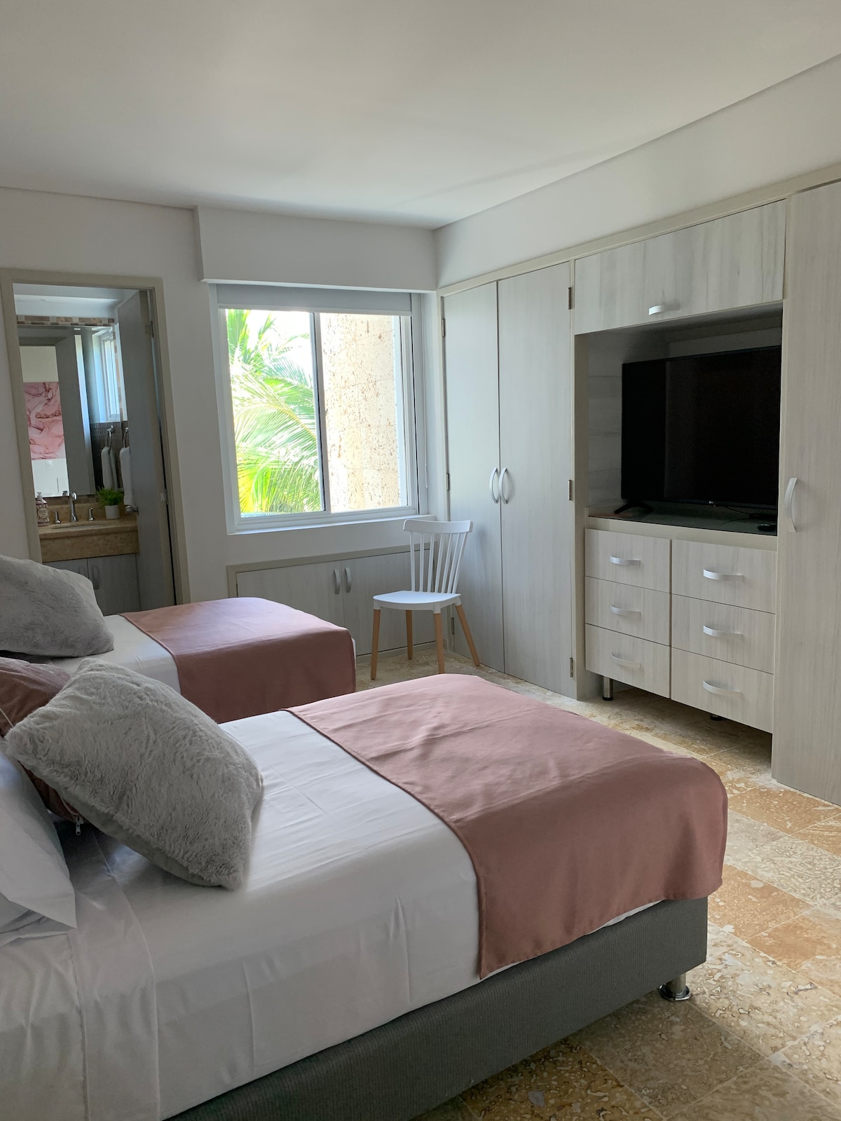 Kamer 2, met twee zeer comfortabele eenpersoonsbedden, tv, lucht, ruime kast en verlichting en raam plus koraalstenen badkamer.