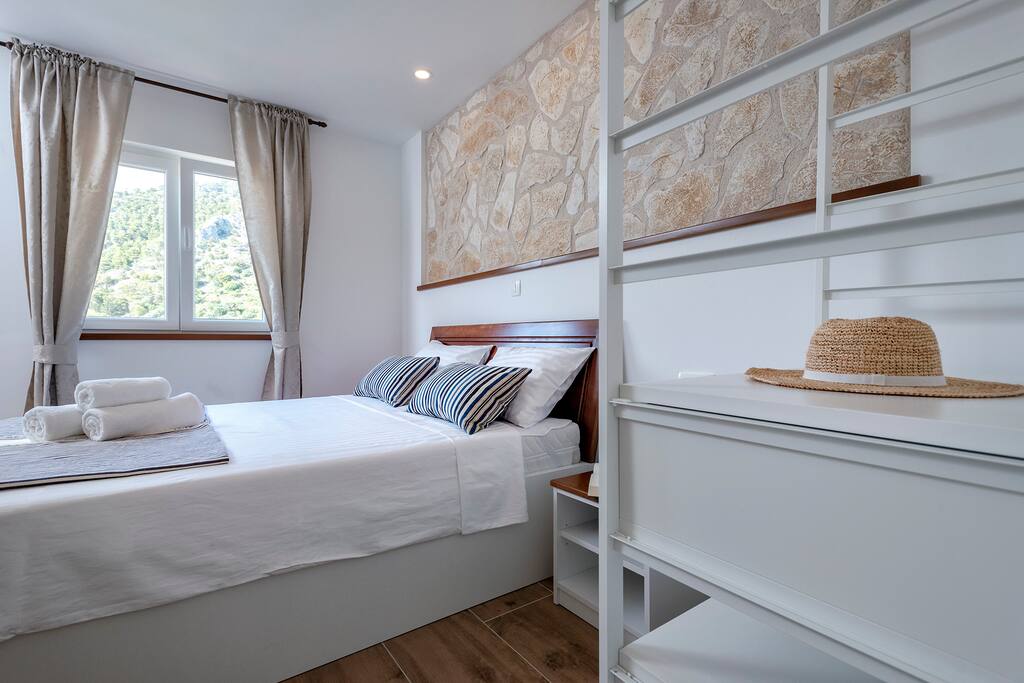 Double bed inside the old stone house, which keeps the temperature nice and cool. The room has A/C and satellite smart TV