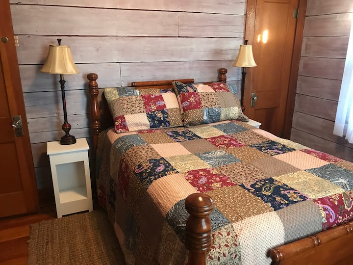  2. földszinti hálószoba, eredeti, fehérre meszelt falak és gyönyörű padlóburkolat. Queen méretű ágy.