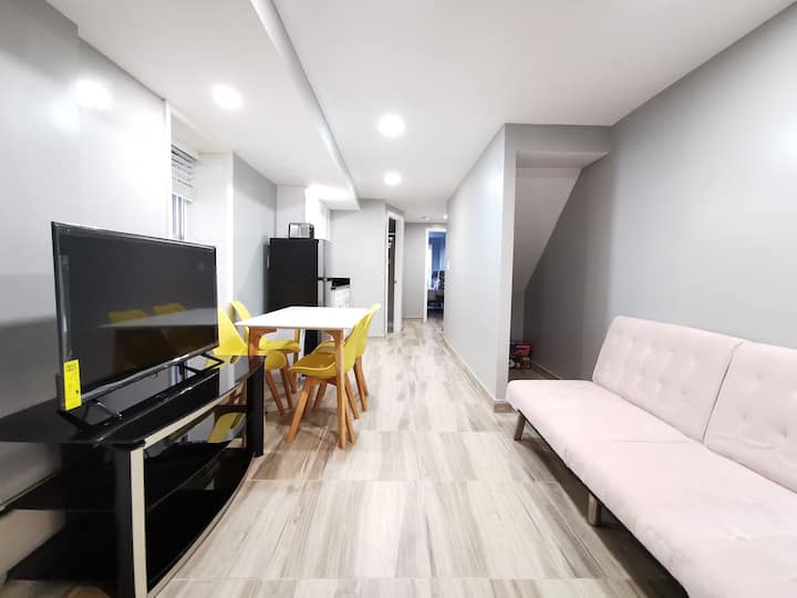 客厅配备一张沙发床、43英寸4K电视和小餐桌