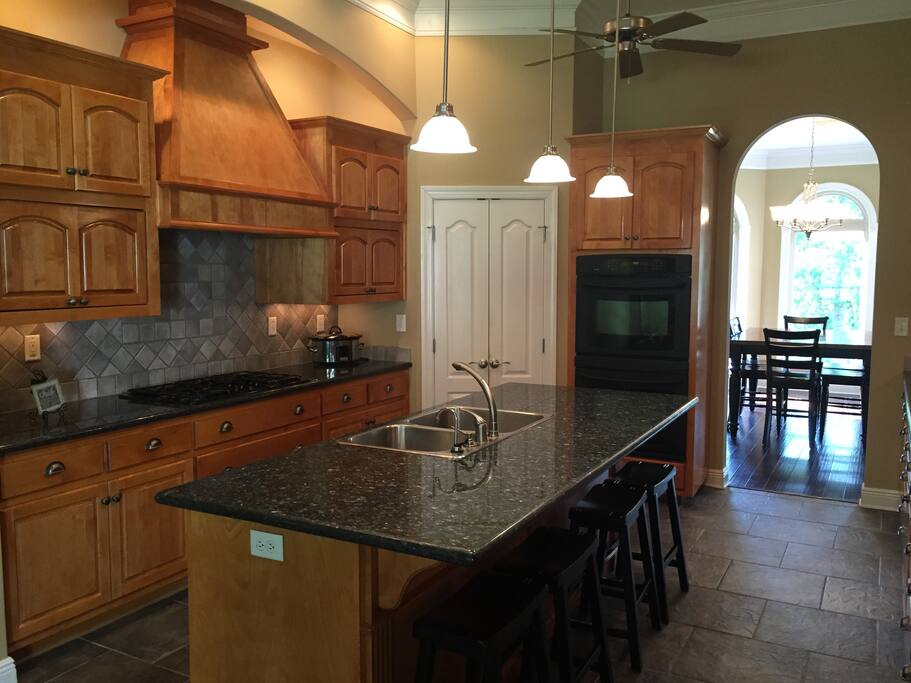 Kitchen - 4 stools at the island, double ovens and gas stove