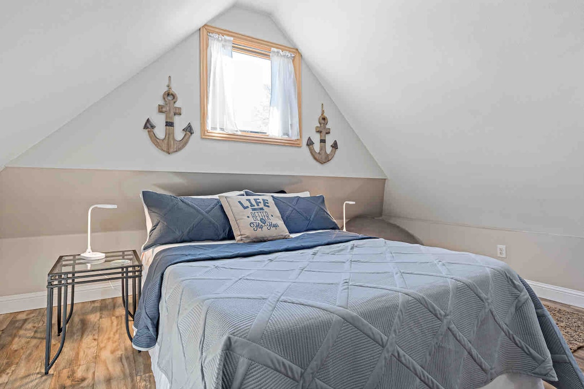 Charming, peaceful, and just the right size. This upstairs bedroom is filled with soft light and nautical touches—perfect for teens, grandkids, or anyone who loves a cozy hideaway.