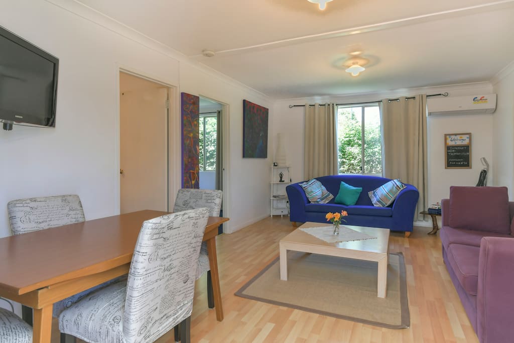 Lounge/dining area with TV and doors leading into bedrooms