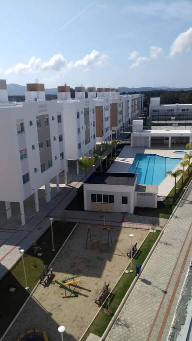 Parquinho infantil e piscina ao fundo