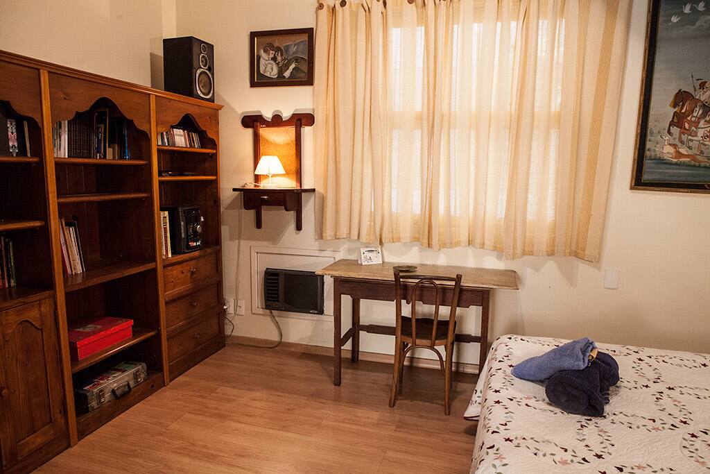 Quarto 1 - vista da estante e escrivaninha (mesa de apoio para computador)