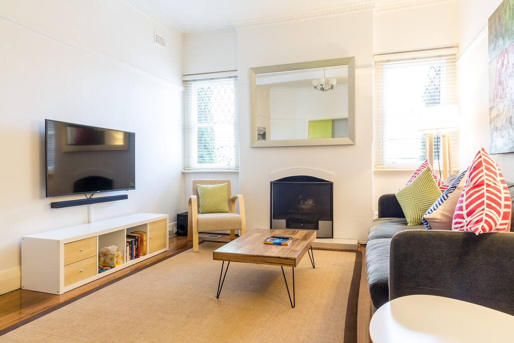 Living room, large TV, soundbar, Apple TV with Netflix and Apple music subscription