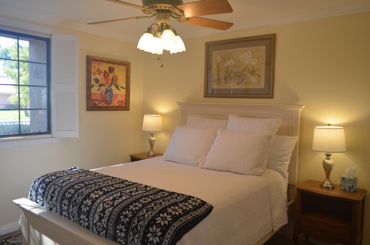 Dormitorio queen con vista con ropa de cama blanca.