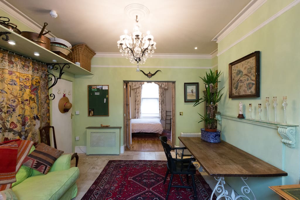 The living room is en-suite to the bedroom, separated by an old arched pine door with glass panels and net curtains.