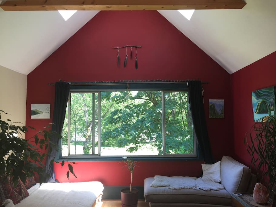 Skylights and vaulted ceiling with exposed beams and dimmer lights in the living room.