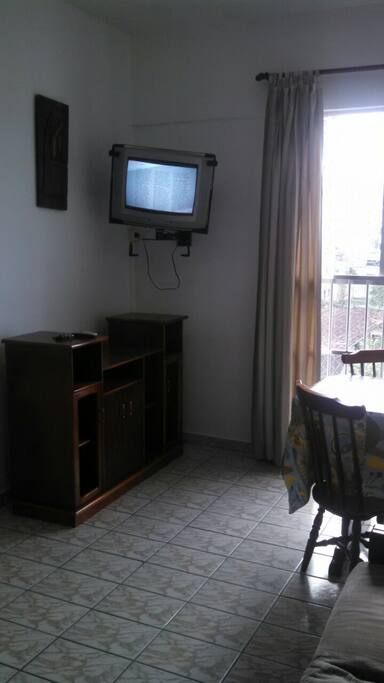 sala com mesa de jantar, tv e sofá