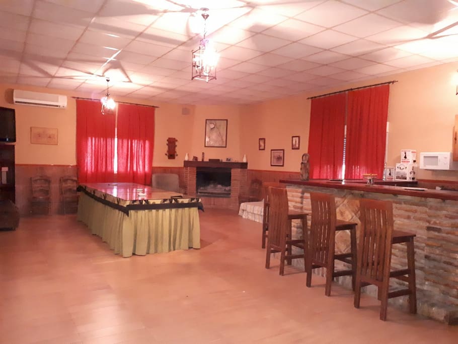Salón con cocina abierta, ideal para invierno con la chimenea o en verano con el aire.