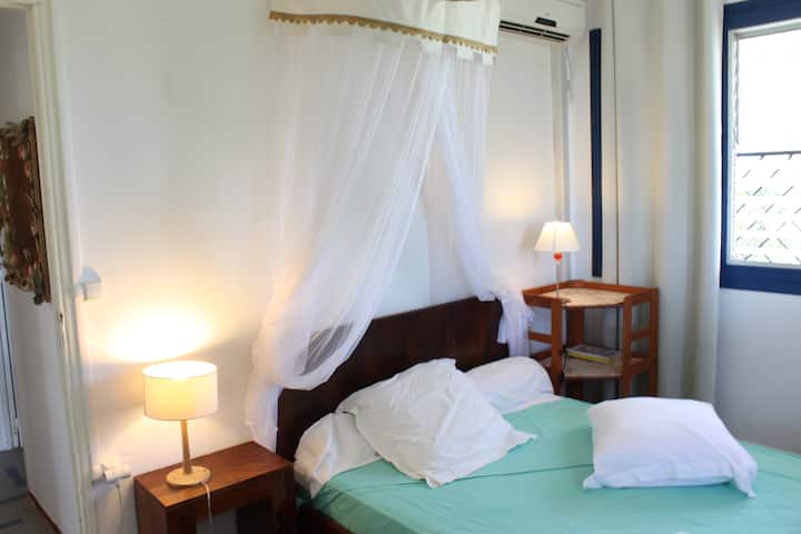 غرفة النوم الثانية مع نوافذ إلى الحديقة