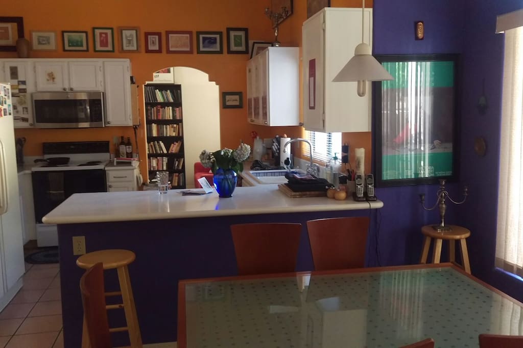 Well equipped kitchen with many pots, pans, plates, and utensils.