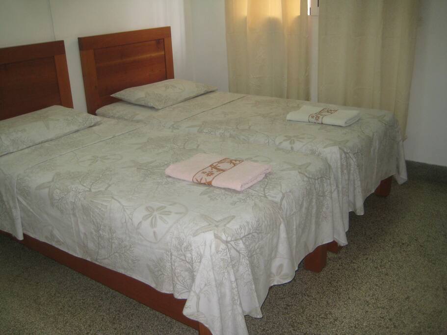 Habitación 2, dimensiones 4x4, climatizada con baño individual y 2 camas individuales.