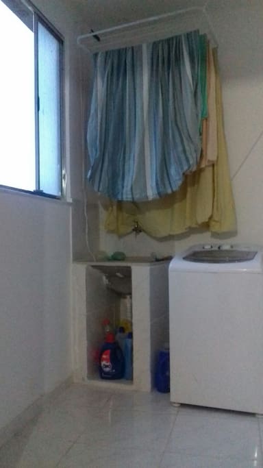 Área de serviço com máquina de lavar e varal