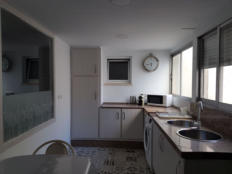 Cocina equipada con frigorifico con congelador, inducción, horno, microondas, cafetera y lavadora