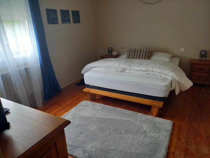 Chambre 1 grand lit double vue sur la petite terrasse. 
TV. 