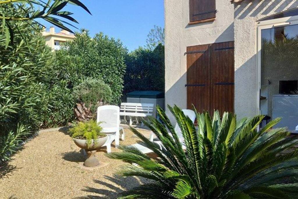 Le jardin avec chaises longues et table pour barbecue électrique