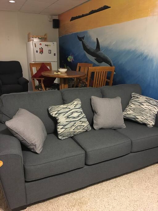 Living room space has new couch, table and refrigerator