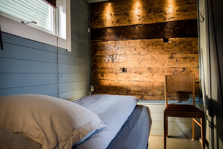 Bedroom 3  - with a window and original timber wall.