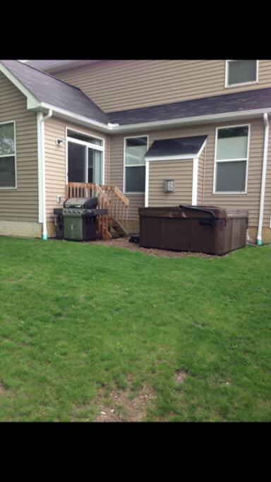 Back of the house, new hot tub and gas grill.