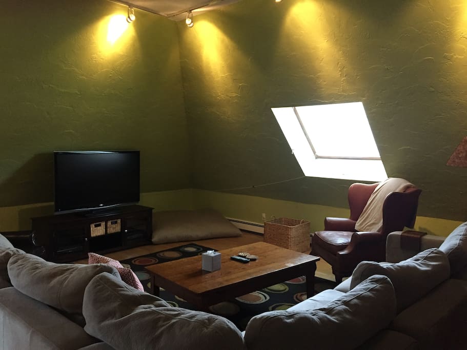 Comfortable living area with skylight, sectional and 55-inch TV