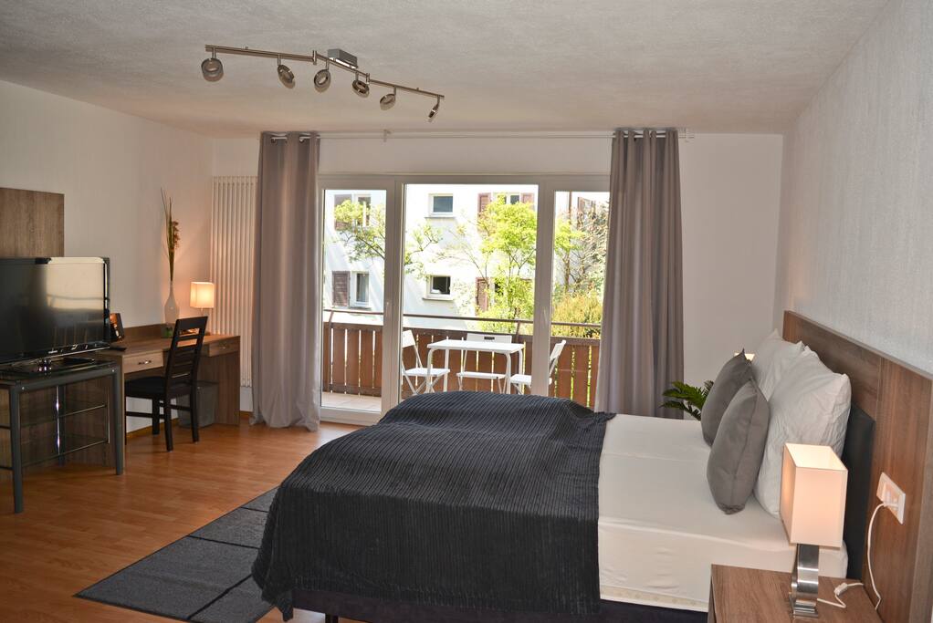 Schlaf-, Wohn- und Arbeitsbereich mit Blick auf großem Balkon