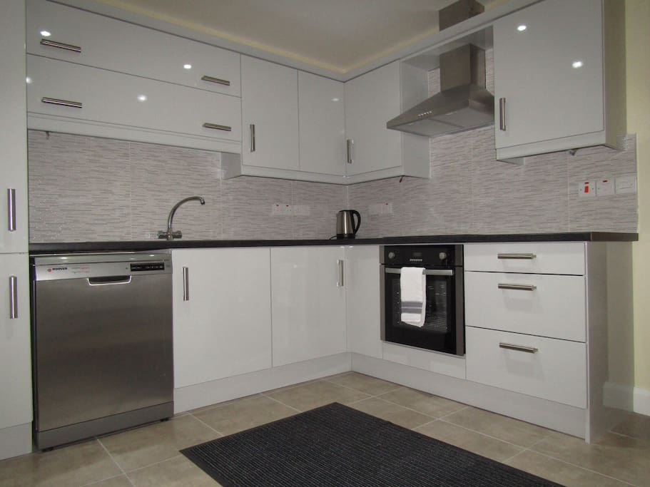 Kitchen in apartment, with dishwasher, large fridge-freezer, kettle and cutlery plates etc