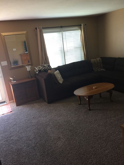Living room with large comfy sectional couch with xfinity cable TV and internet