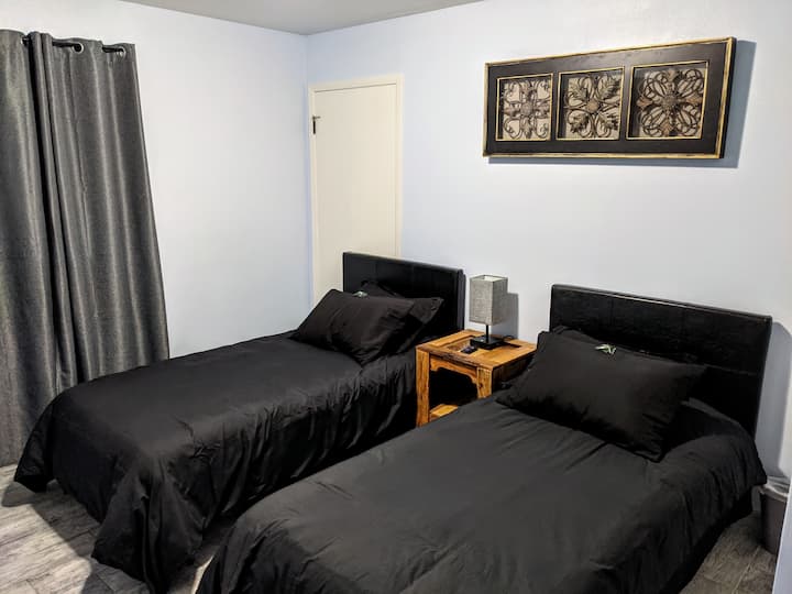 Third bedroom with two comfy twin beds and large 4K smart TV and closet