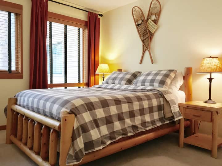 el dormitorio principal cuenta con una cama rústica de tronco tamaño queen
