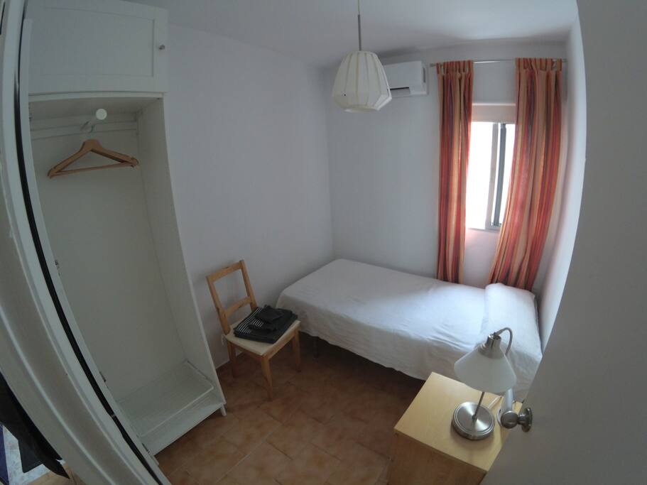 Una de las habitaciones con la puerta abierta del armario (fotografía tomada con objetivo angular)
