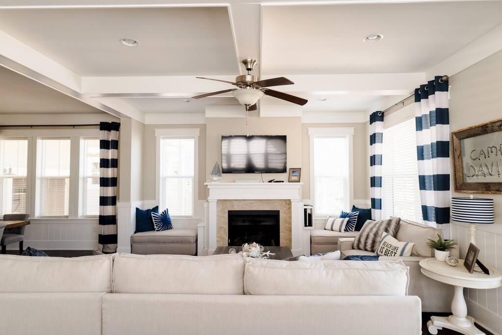 Open concept living and dining area with flat screen tv and fireplace.